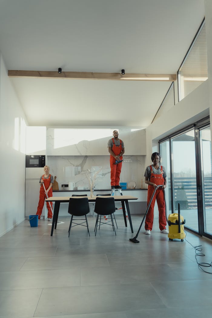 services-04 Team of professional cleaners working in a spacious, modern indoor setting.